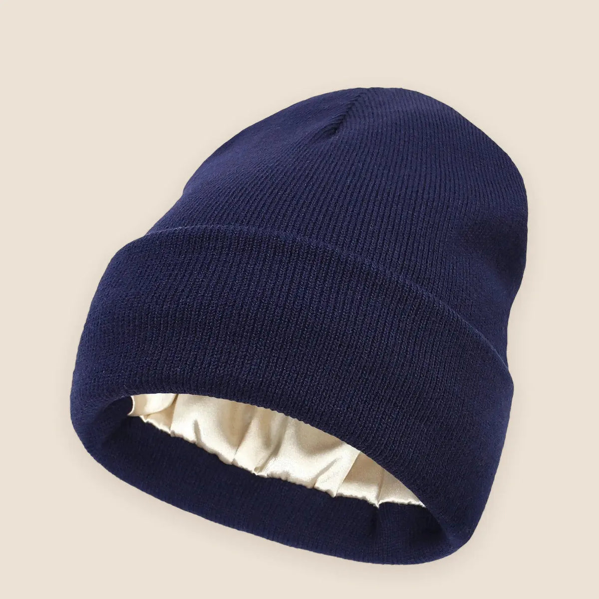 Women's satin lined beanie on a warm neutral background