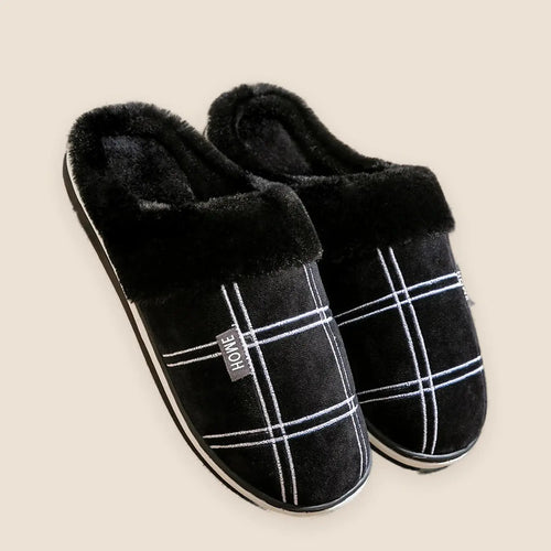 Men's plaid flannel house slippers on a warm neutral background
