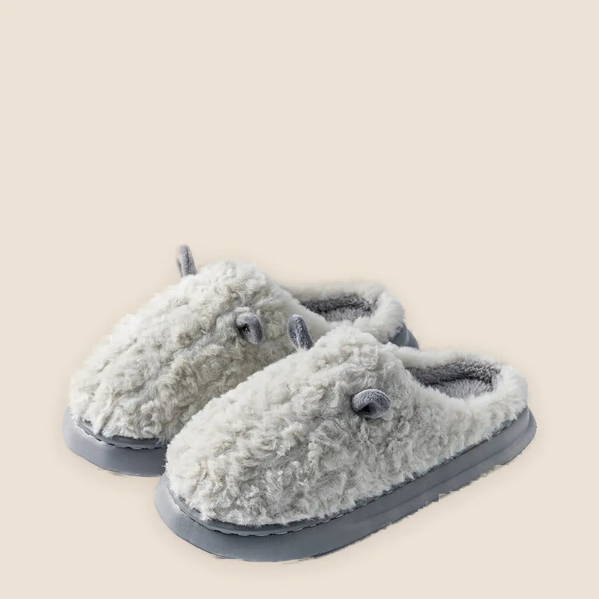 Women's fleece lined house slippers on a warm neutral background